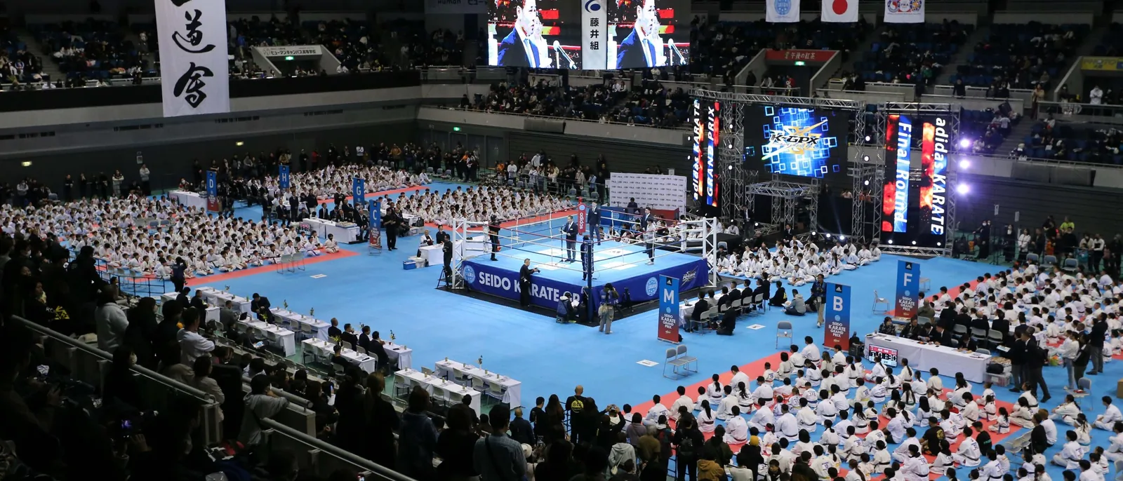 全国決勝大会の会場全景。中央のリングを囲んで多数の選手が着座している